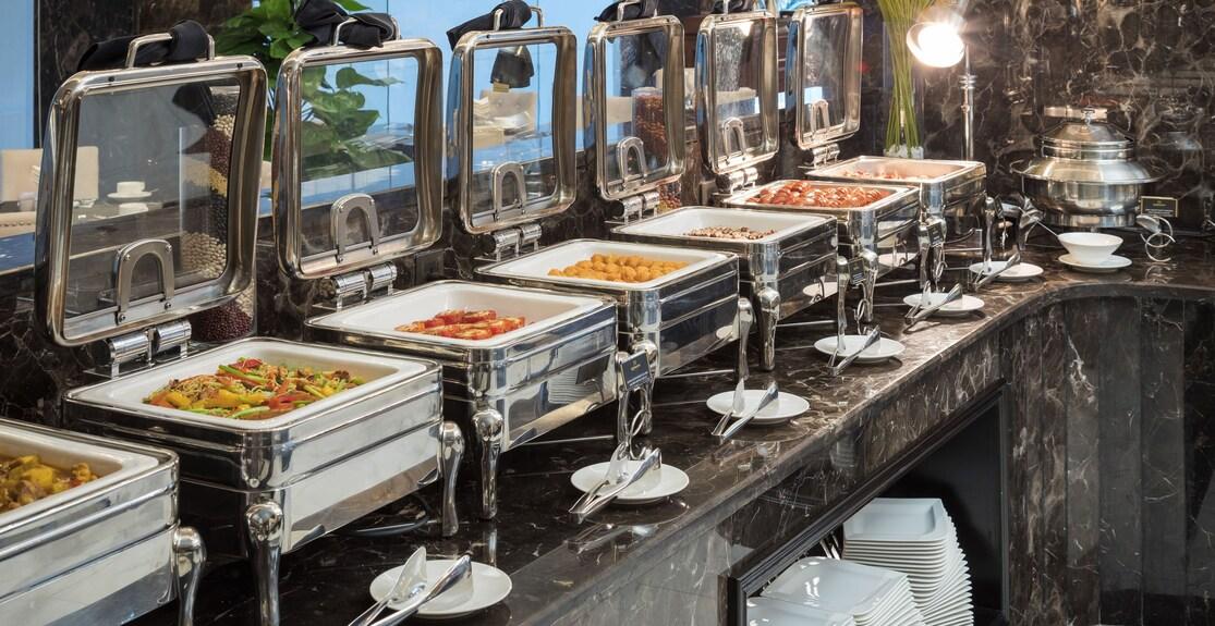 Commercial chafing dishes arranged along a hotel buffet line
